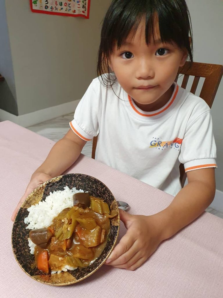 Rina presenting curry dish during international day