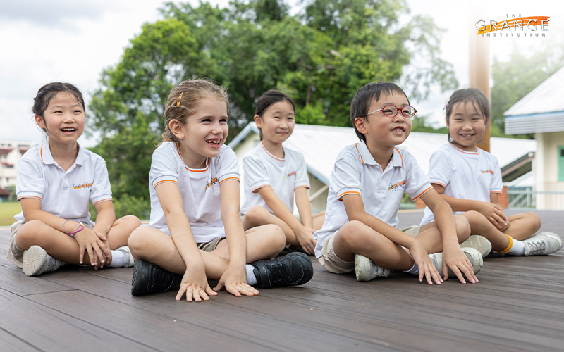 Happy students sitting outside at The Grange Institution.
