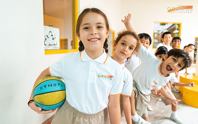 Students at an international school happily lining up with a ball.
